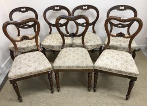 A set of four Victorian harebell carved shaped balloon back dining chairs on moulded cabriole legs