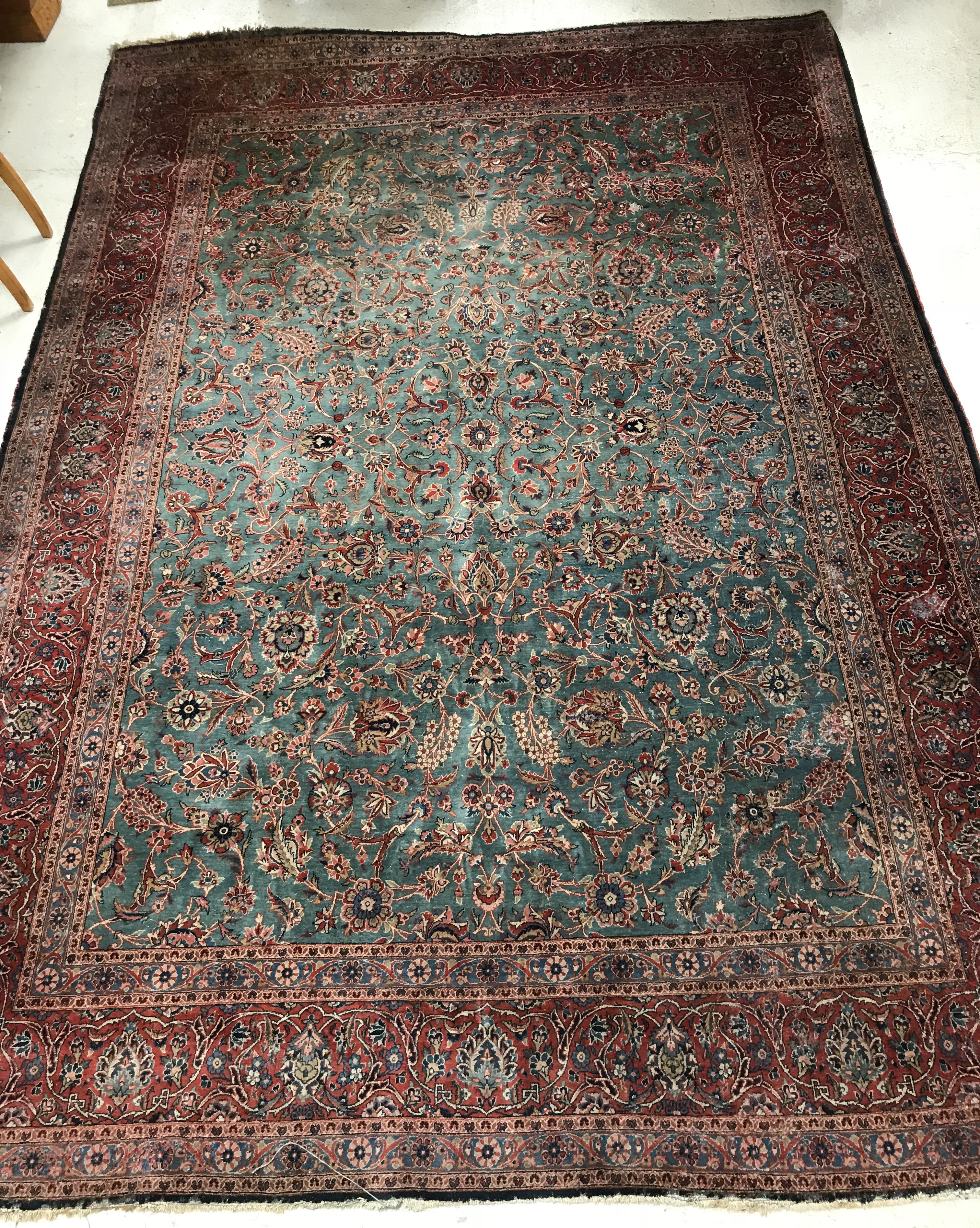 A Persian carpet, the central panel set with all-over scrolling foliate design on a teal ground,