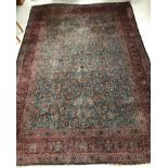 A Persian carpet, the central panel set with all-over scrolling foliate design on a teal ground,