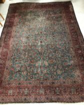 A Persian carpet, the central panel set with all-over scrolling foliate design on a teal ground,
