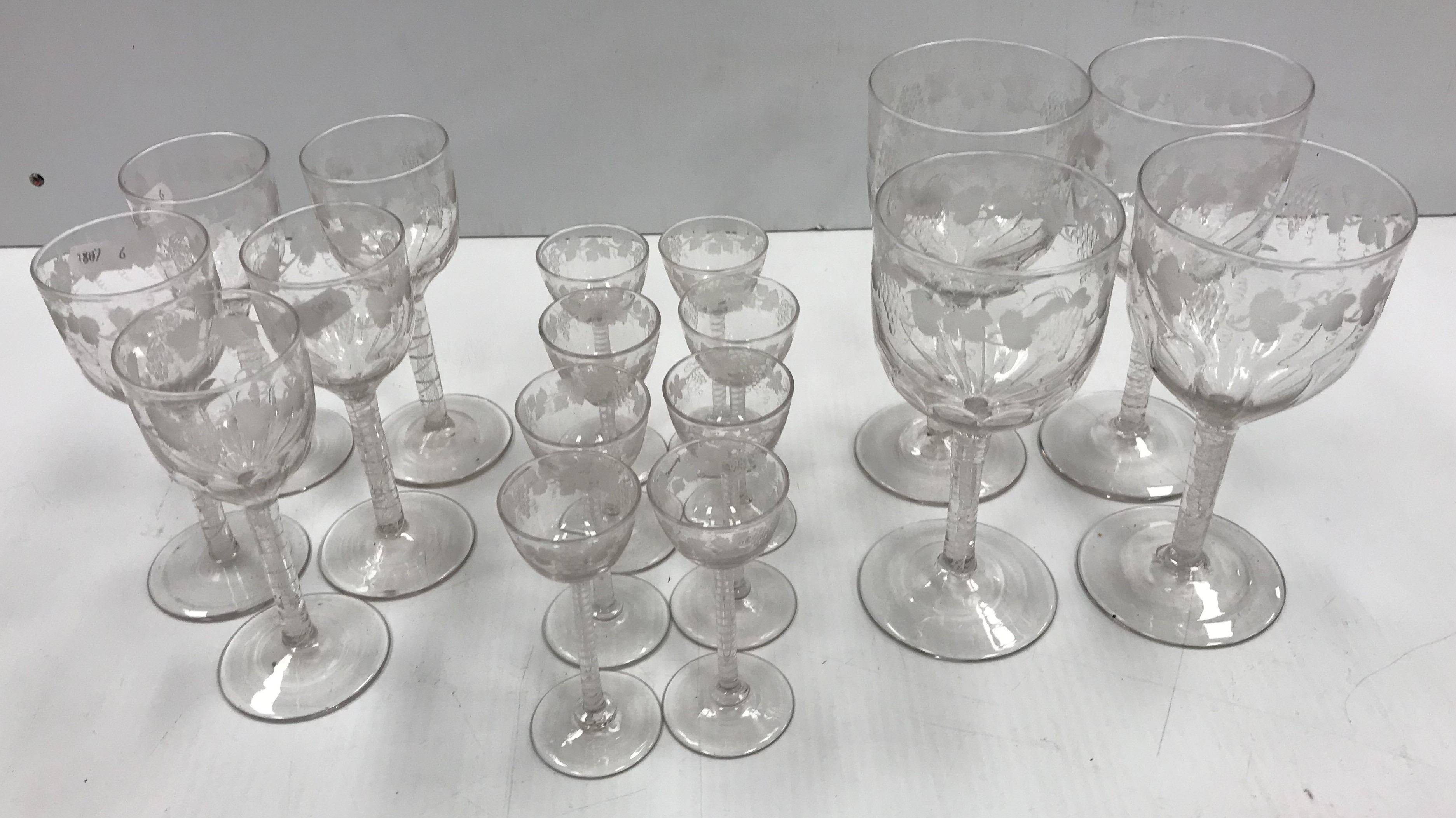 A set of circa 1920 grape and vine etched drinking glasses on enamel twist stems in the 18th