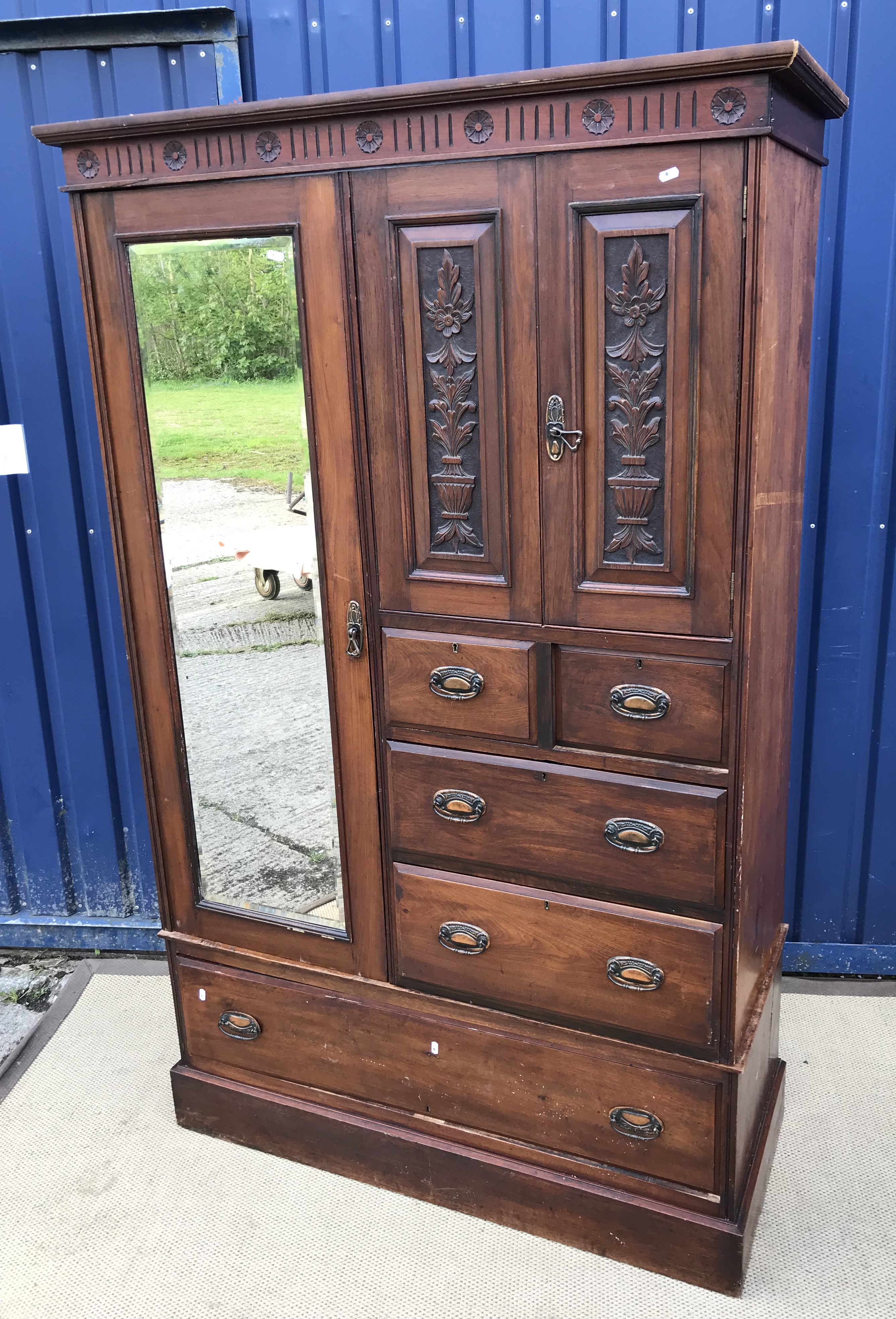 A late Victorian mahogany wardrobe compactum with single bevel edged mirror door and two carved