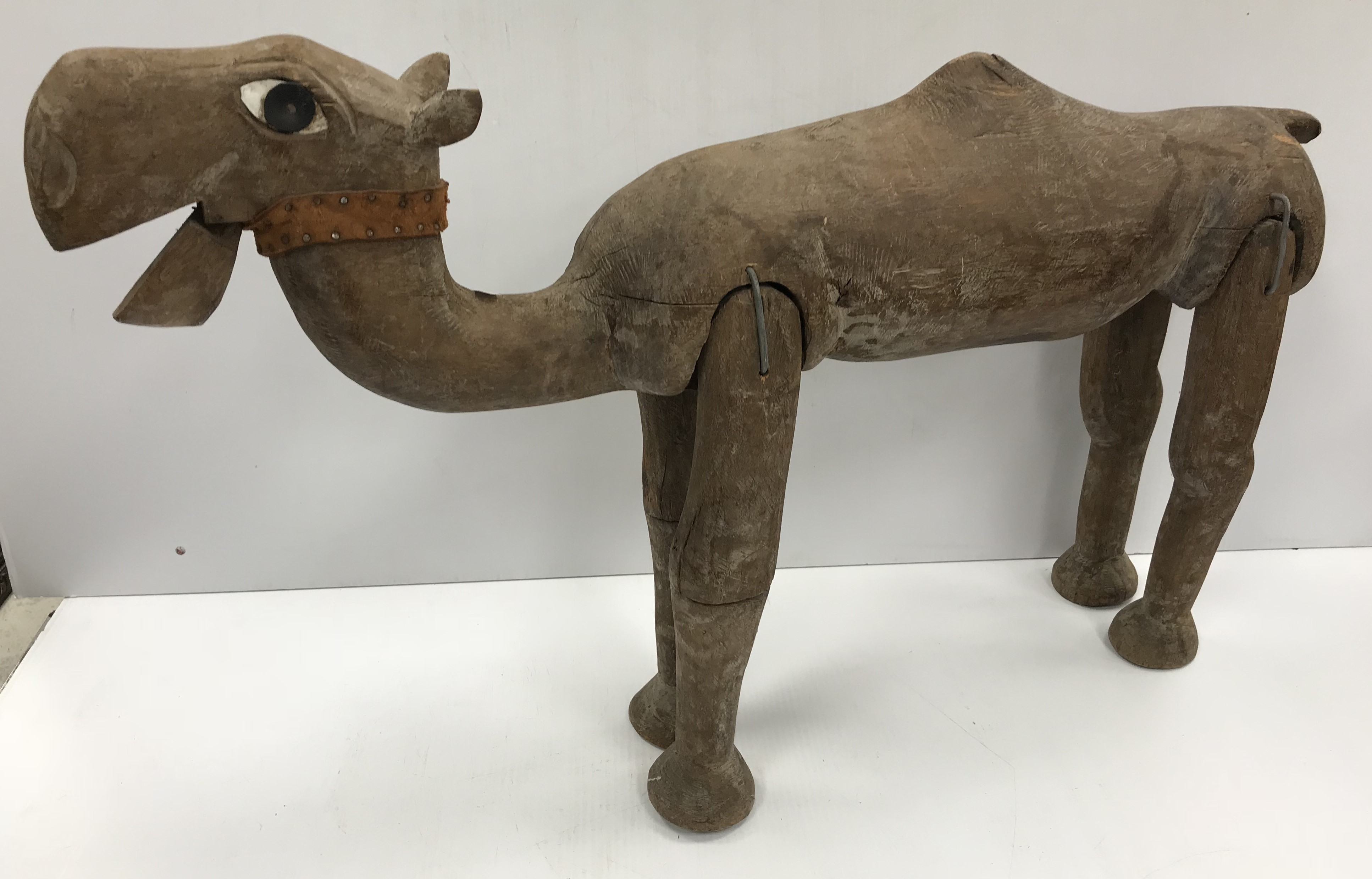 A carved treenware figure of a dromedary camel with basic articulated legs and jaw 51 cm high x 83