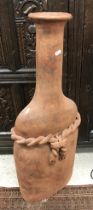 A modern terracotta bottle of large proportions with rope detail 90 cm high