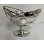 A Victorian silver sugar basket of navette form with beaded edge and swing handle over a fruit and