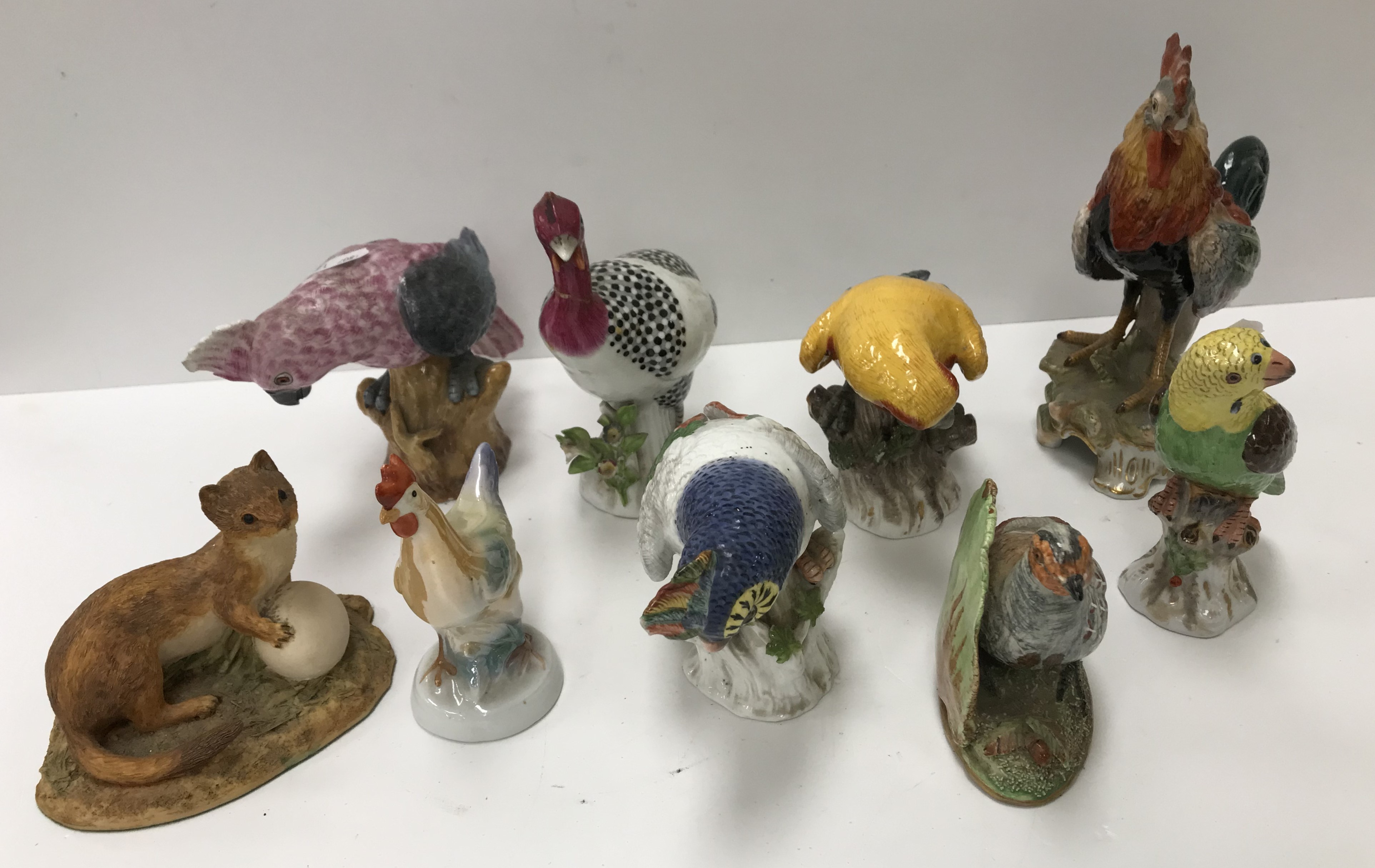 A collection of four Potschappel Dresden bird figures including three various Parrots and Cockerel,