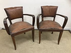 A pair of 1930s beech framed brown leather upholstered elbow chairs on square tapered slightly