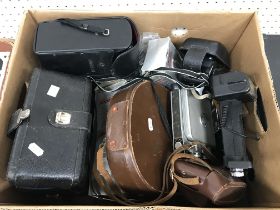 A collection of various cameras and photographic equipment including a Minolta Zoom 8 cine camera,