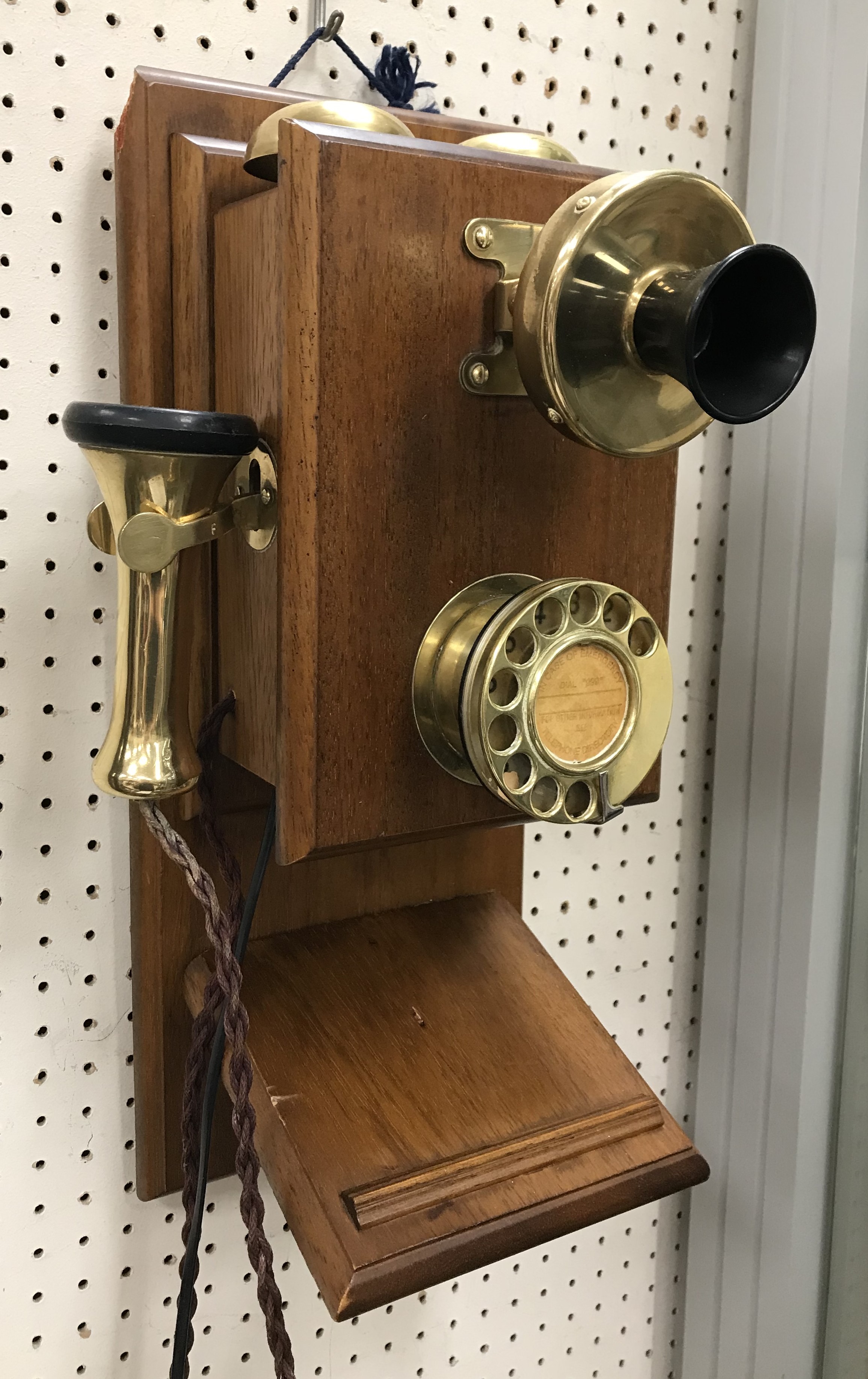 A vintage mahogany cased and brass wall mounted telephone with twin bells 23 cm wide x 45 cm high