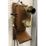 A vintage mahogany cased and brass wall mounted telephone with twin bells 23 cm wide x 45 cm high