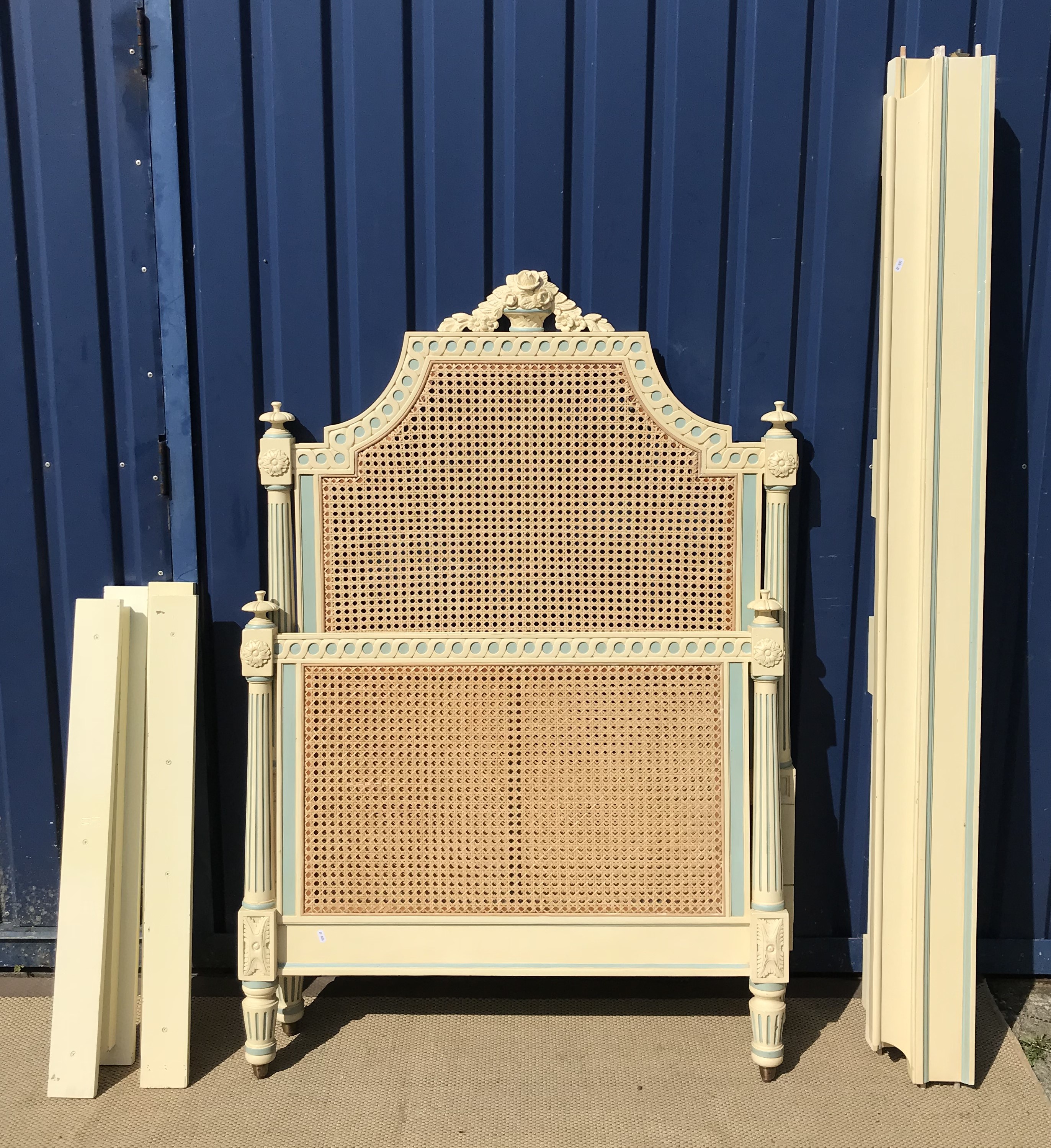 A duck egg blue and cream painted caned single bedstead in the French taste by And So To Bed with