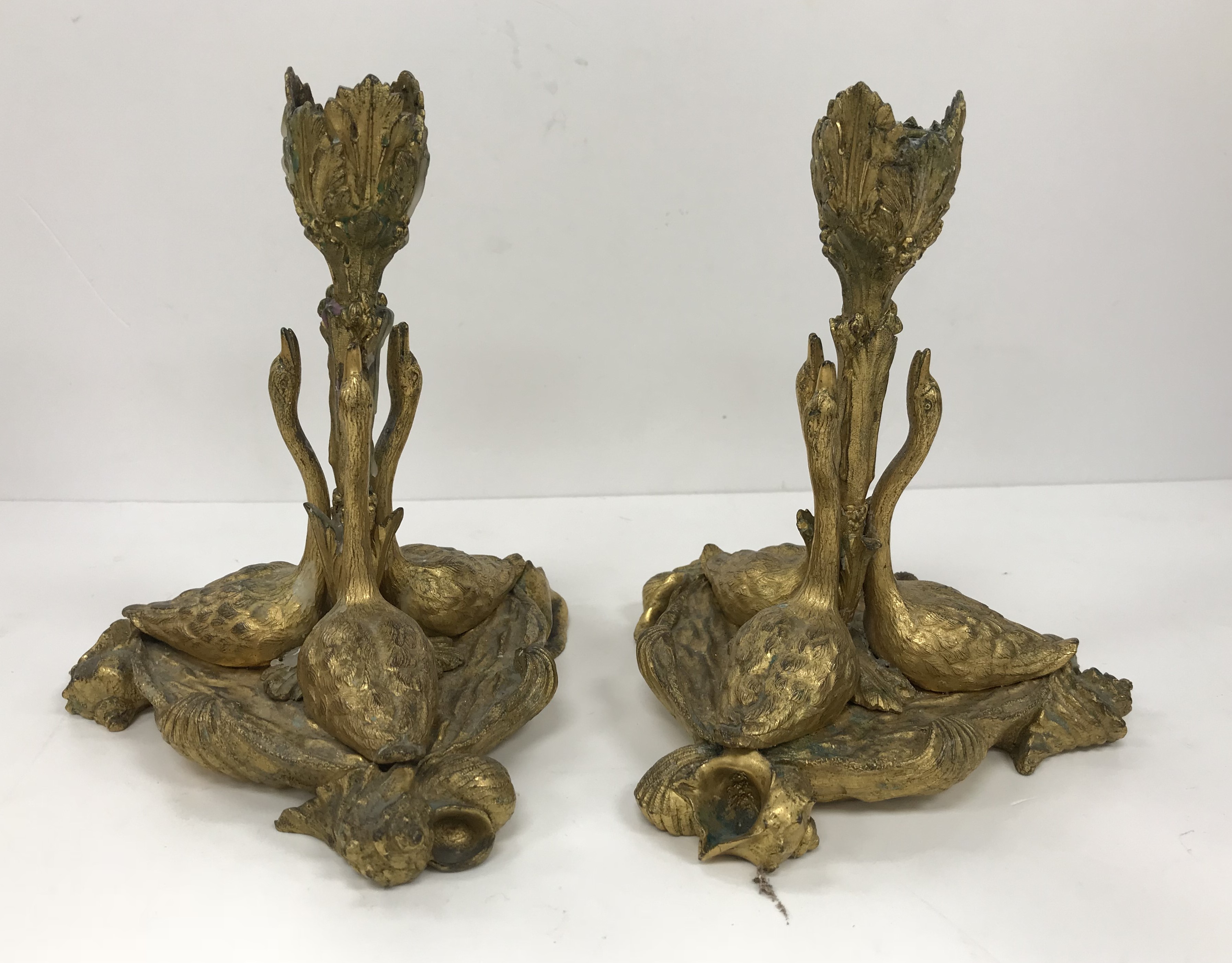 A pair of 19th Century gilt bronze candlesticks as three swans with foliate decorated candle holder