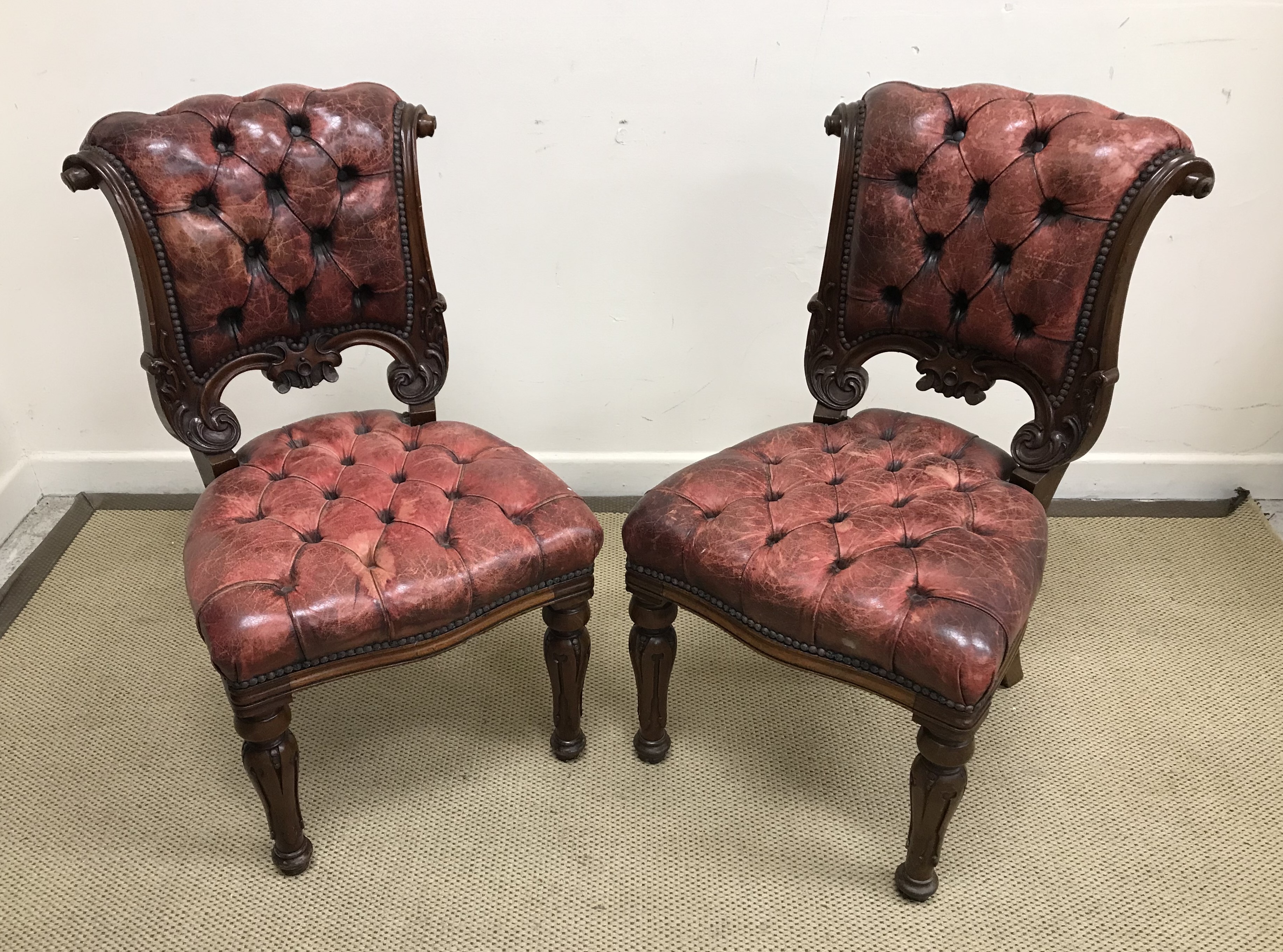 A pair of Victorian mahogany framed and red studded leather upholstered dining chairs,