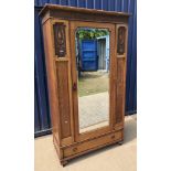 An early 20th Century oak single mirror door wardrobe with carved panelled decoration over a single