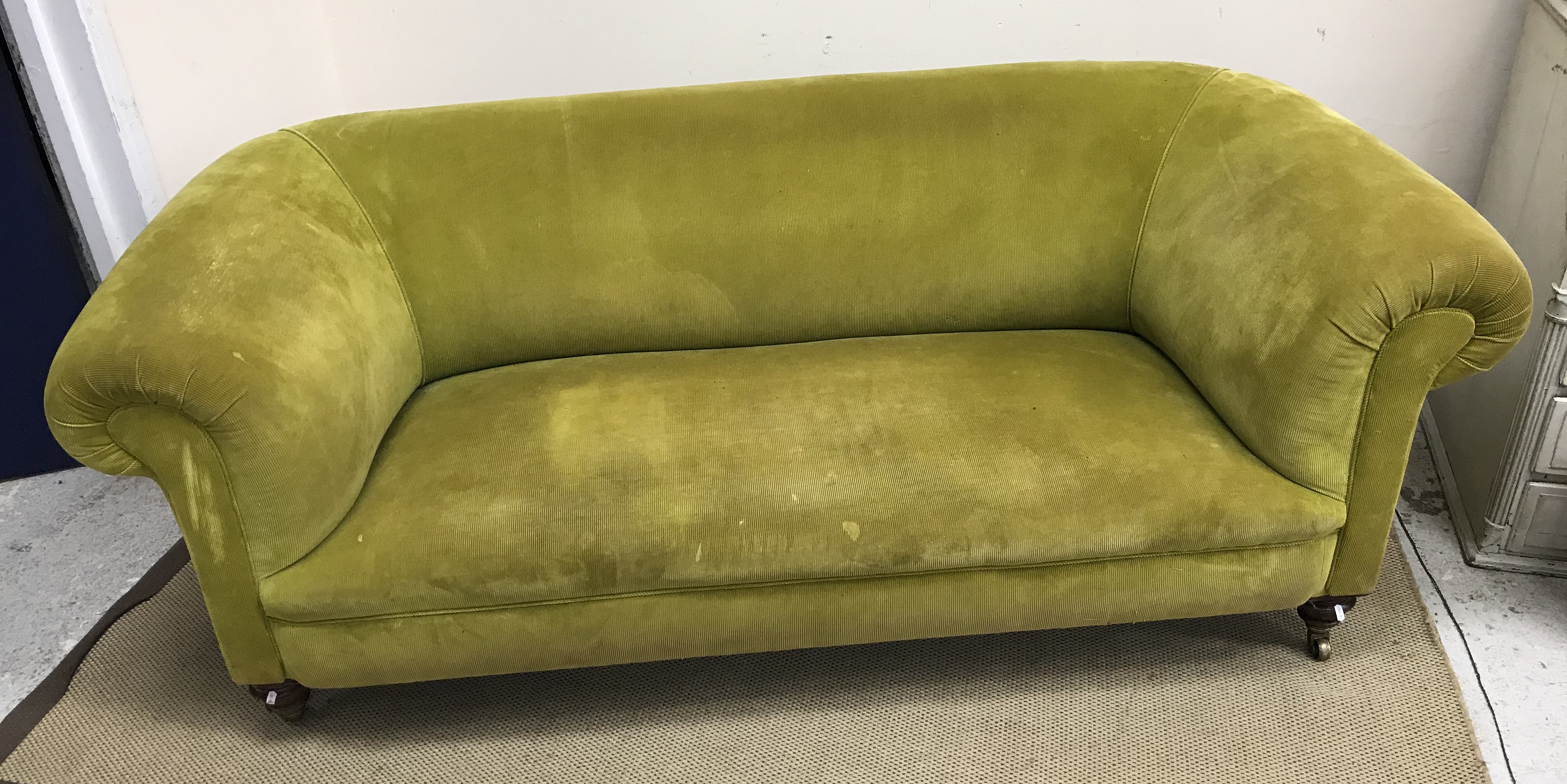 A Victorian Chesterfield sofa in modern lime green corduroy upholstery raised on ringed and turned