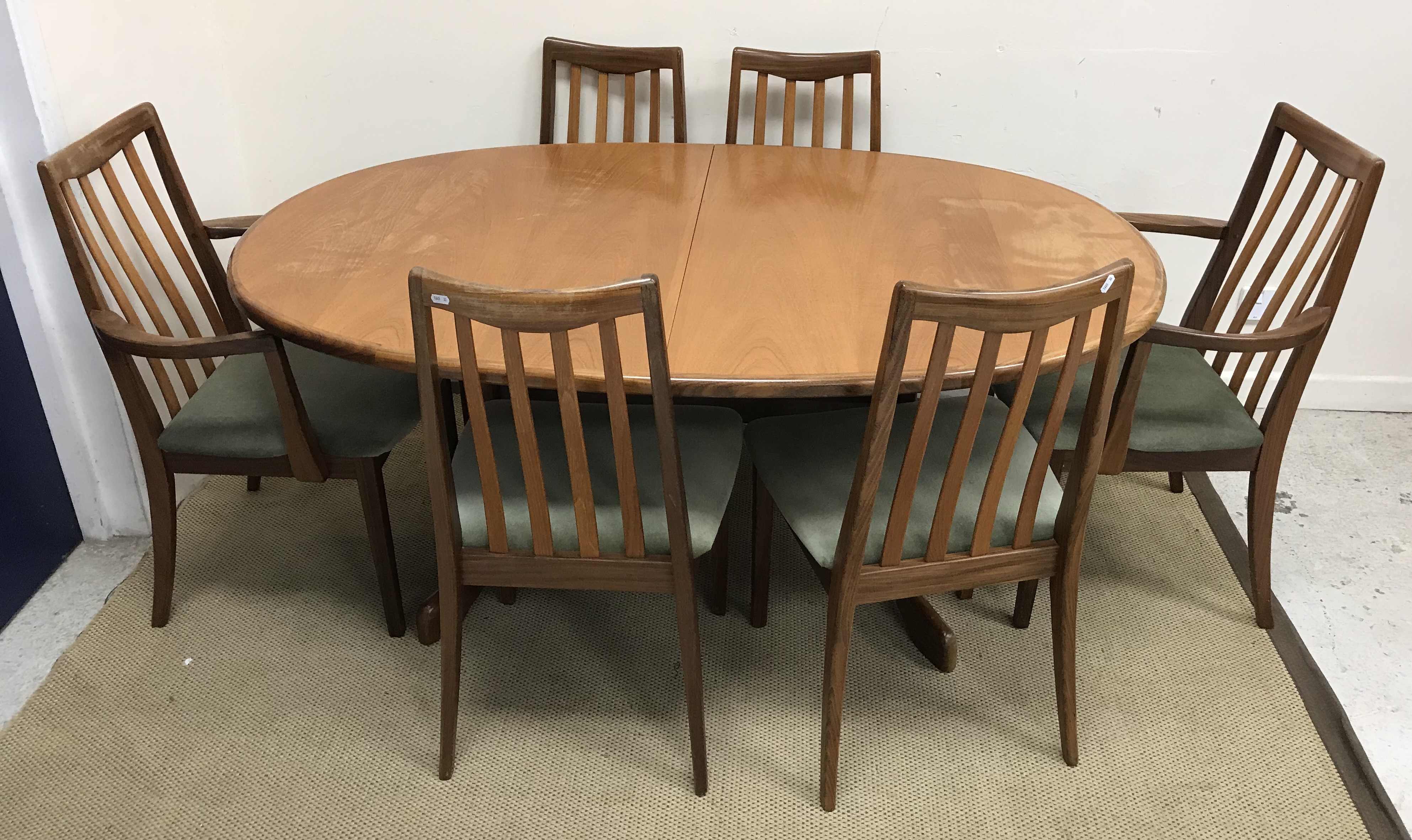 A G Plan teak D end dining table on end pillar supports to curved feet united by a centre stretcher