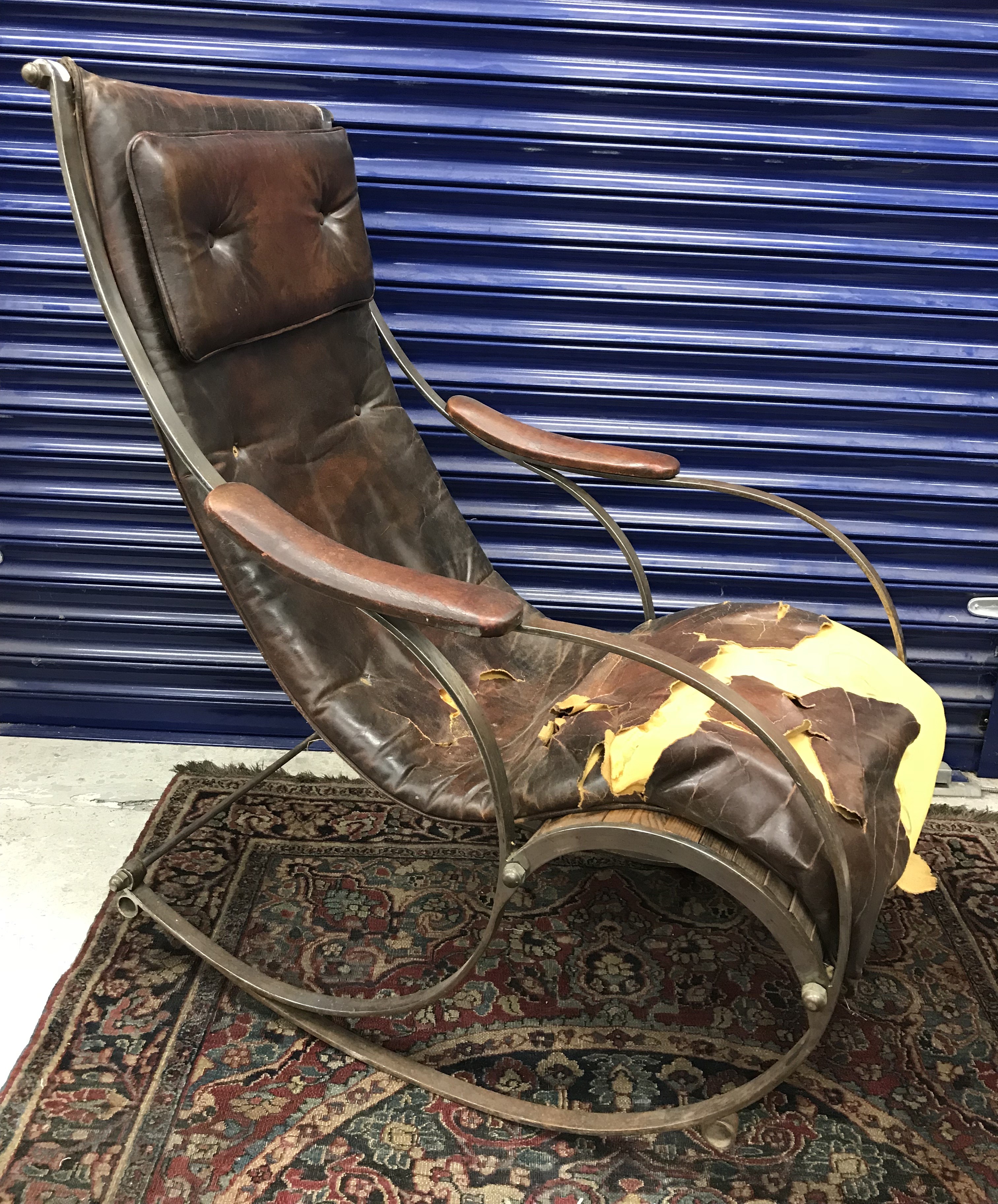 A 19th Century iron framed rocking arm chair in the manner of R.W.