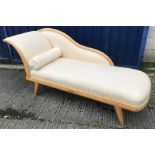 A modern beech framed and ebony strung chaise longue in the Regency taste on splayed square tapered