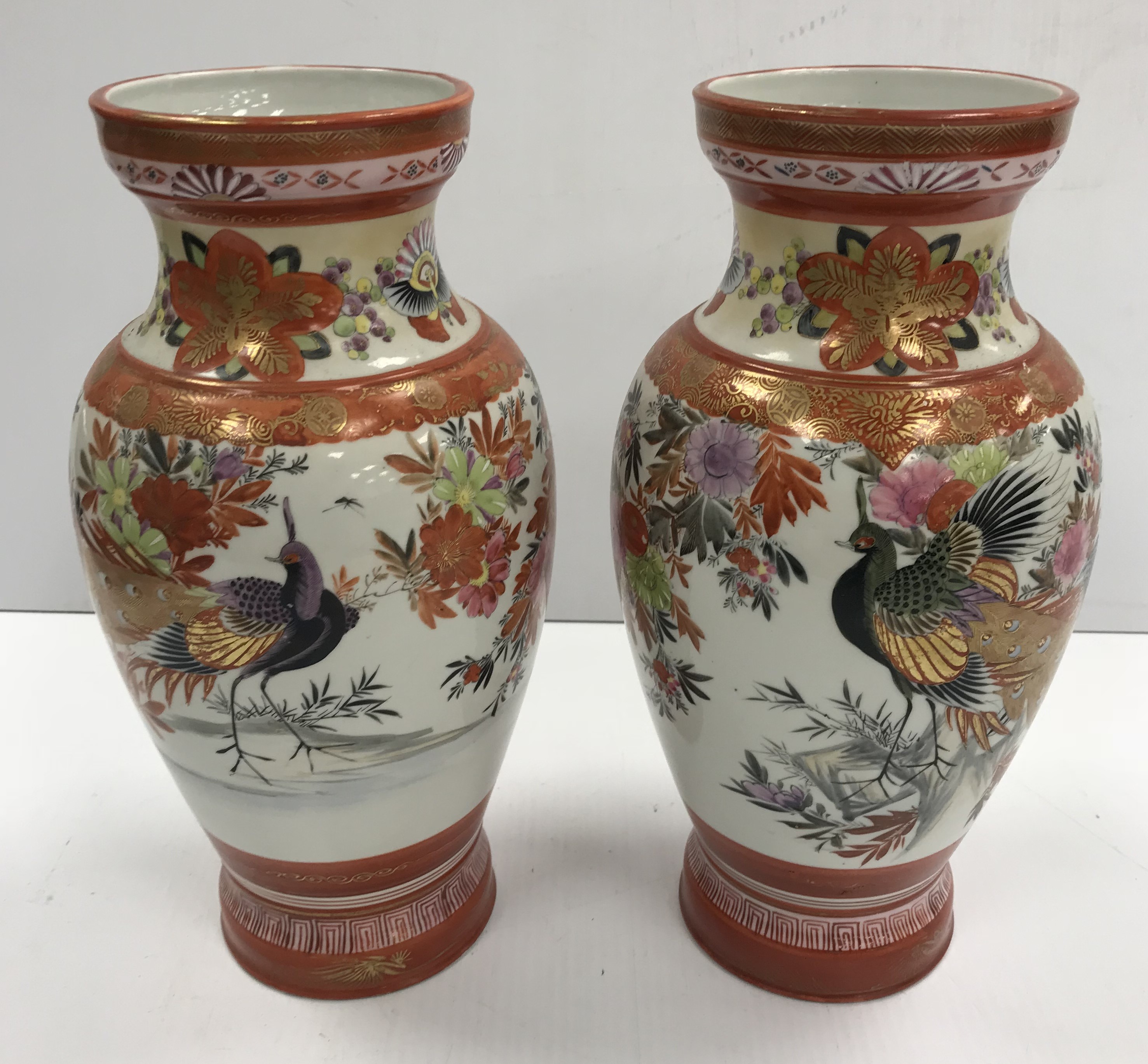 A pair of Japanese Meiji Period Kutani Sei vases decorated with pea fowl amongst flowers and