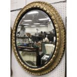 A 19th Century oval gilt framed wall mirror with bevel edged plate,