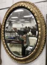 A 19th Century oval gilt framed wall mirror with bevel edged plate,