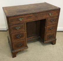 A burr walnut veneered kneehole desk in
