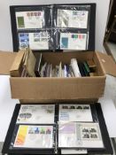 A box containing various unmounted stamps, two albums of first day covers,
