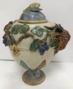 A 19th Century Italian Majolica vase with fruit swag and goat's head relief work decoration on a