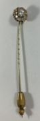 A yellow metal mounted stick pin, the ce