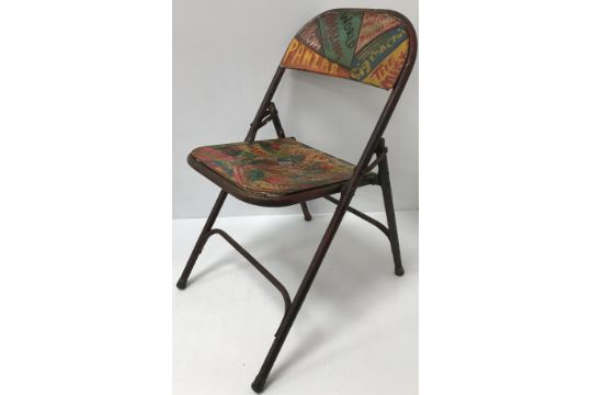 A painted metal vintage style folding chair with colourful face decoration