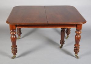 A VICTORIAN MAHOGANY EXTENDING DINING TABLE, to seat eight, moulded rim, on turned legs with brass