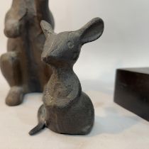 A metal rabbit, a mouse and a dog's head on plinth