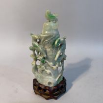 A Chinese jade vase and cover carved as birds sitting in the branches of a peach tree, 16.5cn high