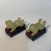 A pair of Chinese green mineral twins, laying, on hardwood stands, approximate 6cm long x 4cm high