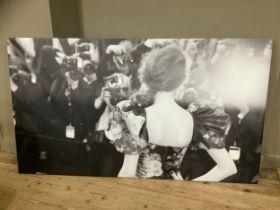 A black and white print on canvas of a woman at a premiere in a floral dress in front of press,