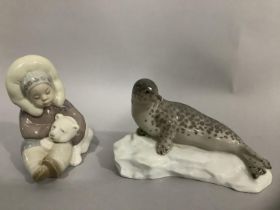 A Lladro figure group of Inuit child and polar bear cub, 12cm high, together with a china figure