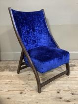 An early 20th century folding chair upholstered in blue crushed velvet to the seat and back