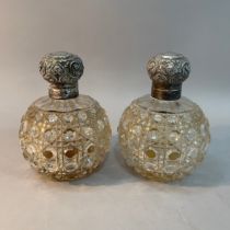 A pair of Edward VII silver lidded cut glass cologne bottles of spherical outline, hobnail cut and