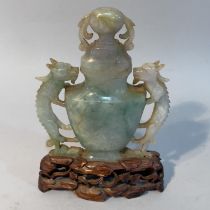 A Chinese jade vase and cover, of urn outline with twin dragon handles, on hardwood stand, 14.5cm