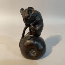 A Heredites series bronze effect resin figure of a field mouse on an apple with it's tail tucked up,