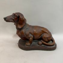 A large resin Dachshund with collar on a base, 38cm high