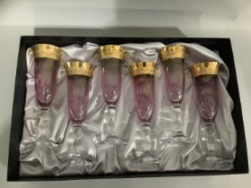 A set of six amethyst Rockingham crystal flutes with gilt banding