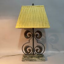 A scrolled metalwork and marble table lamp, wrought with two tiers of opposing bird heads on a