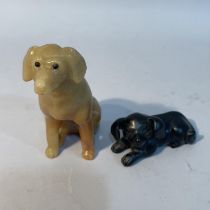 A Chinese black mineral carving of a recumbent dog, 8cm long x 4cm high, together with a soapstone
