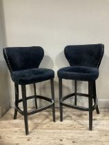 A pair of black bar chairs with close nail studding
