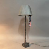 A planished pewter-style table lamp, plain column on circular base, grey silk shade and corded flex,