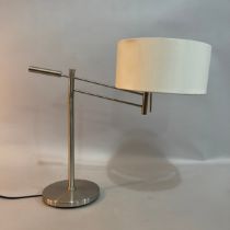 A brushed steel table lamp with cantilever arm on a circular base with cream shade, 51cm high