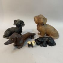 Two wooden carved dachshunds, a composite spaniel and a dachshund money box