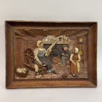 French oak plaque carved in relief with cottage kitchen scene with woman at her spinning whell,