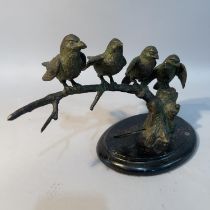 A bronze group of sparrows perched on a branch, on an oval black marble plinth, 31cm wide x 20cm